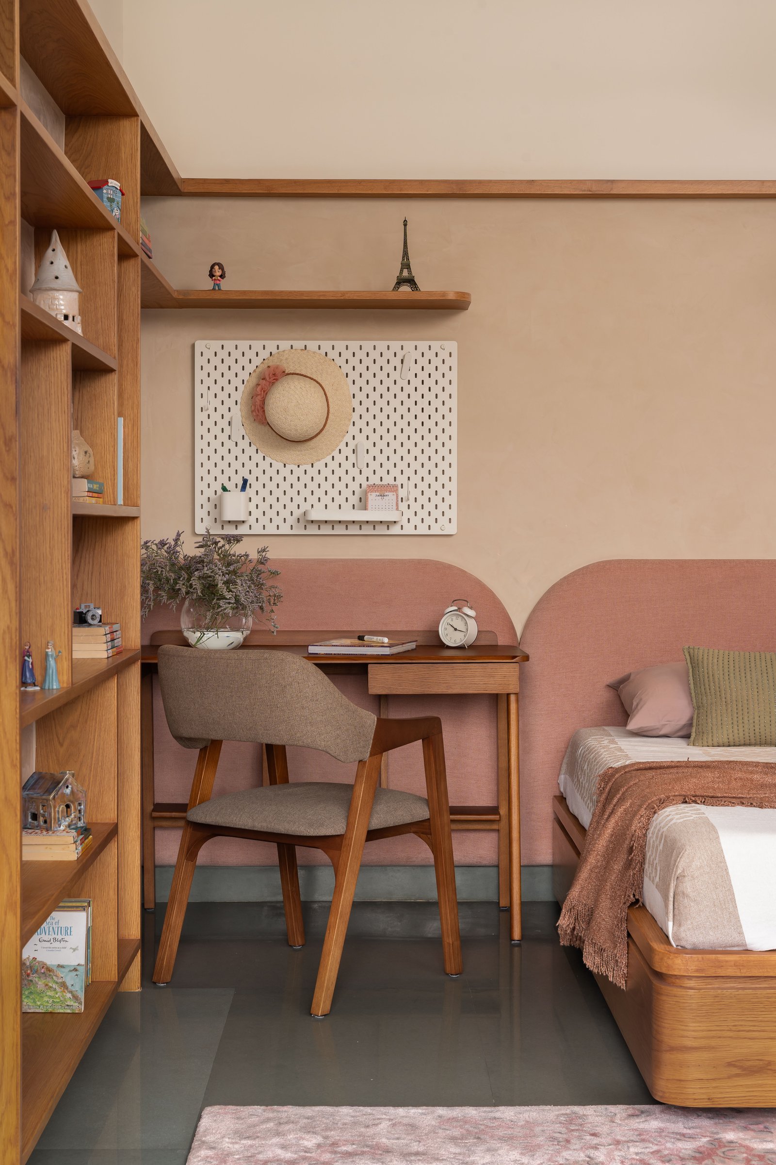 The study corner of the children's bedroom, where desk, shelving, and arched headboard share the same compositional logic