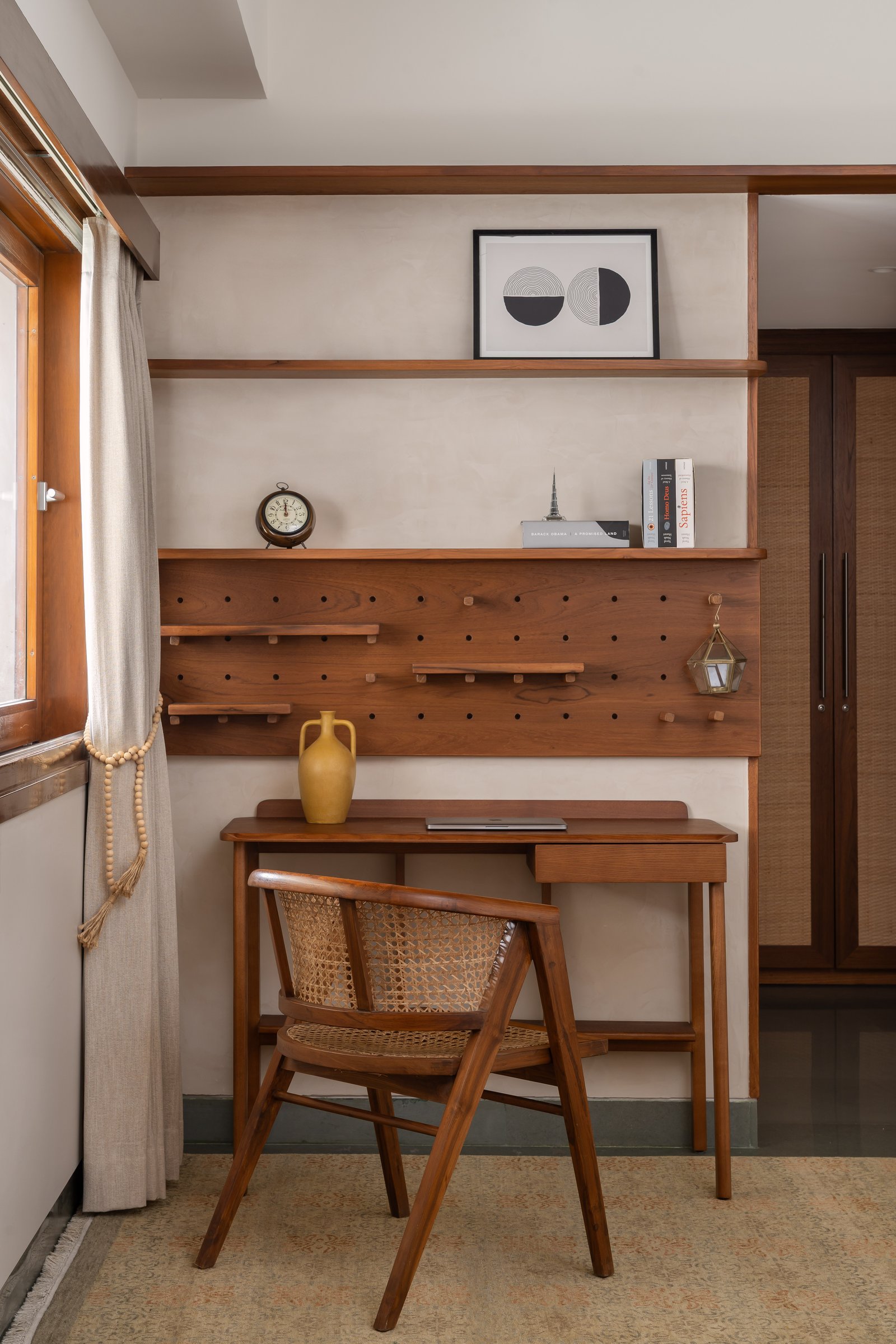 The master study nook: a custom timber pegboard wall and cane-back chair make the utilitarian quietly beautiful