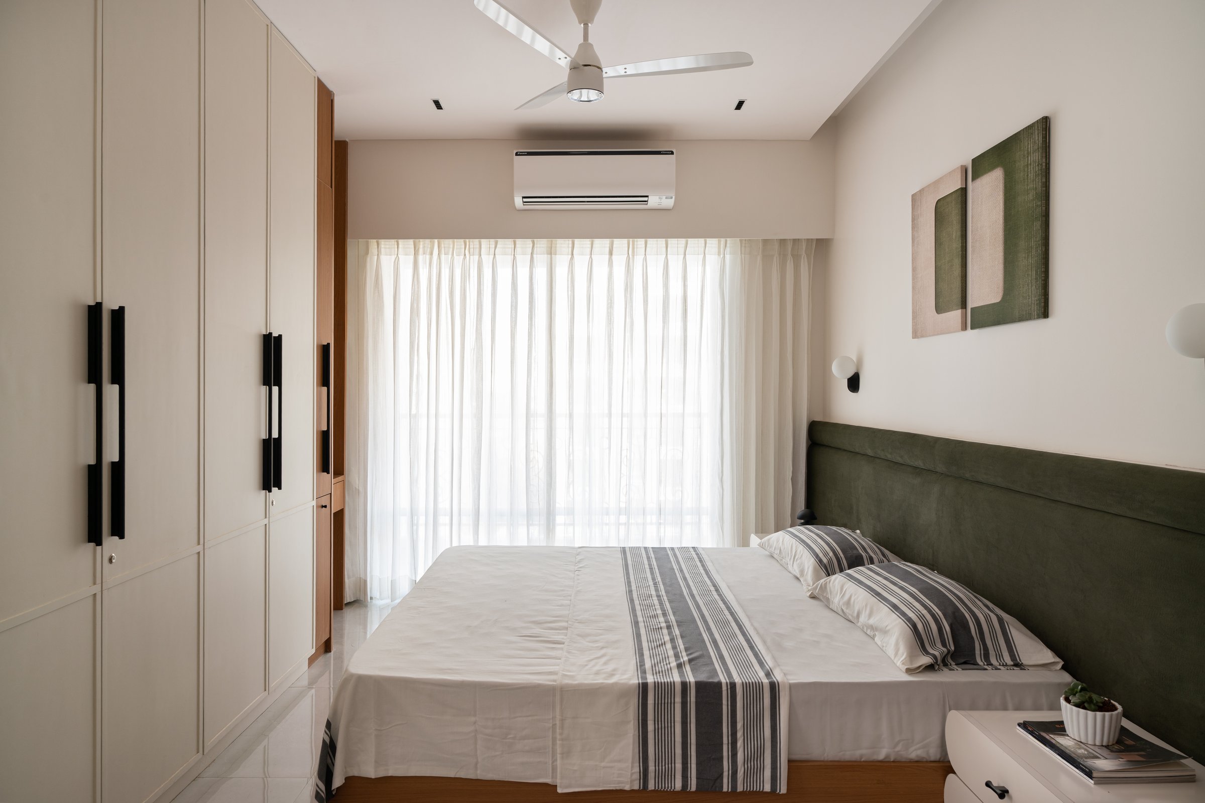 Panelled wardrobes and diffused light give the bedroom a settled, unhurried quality