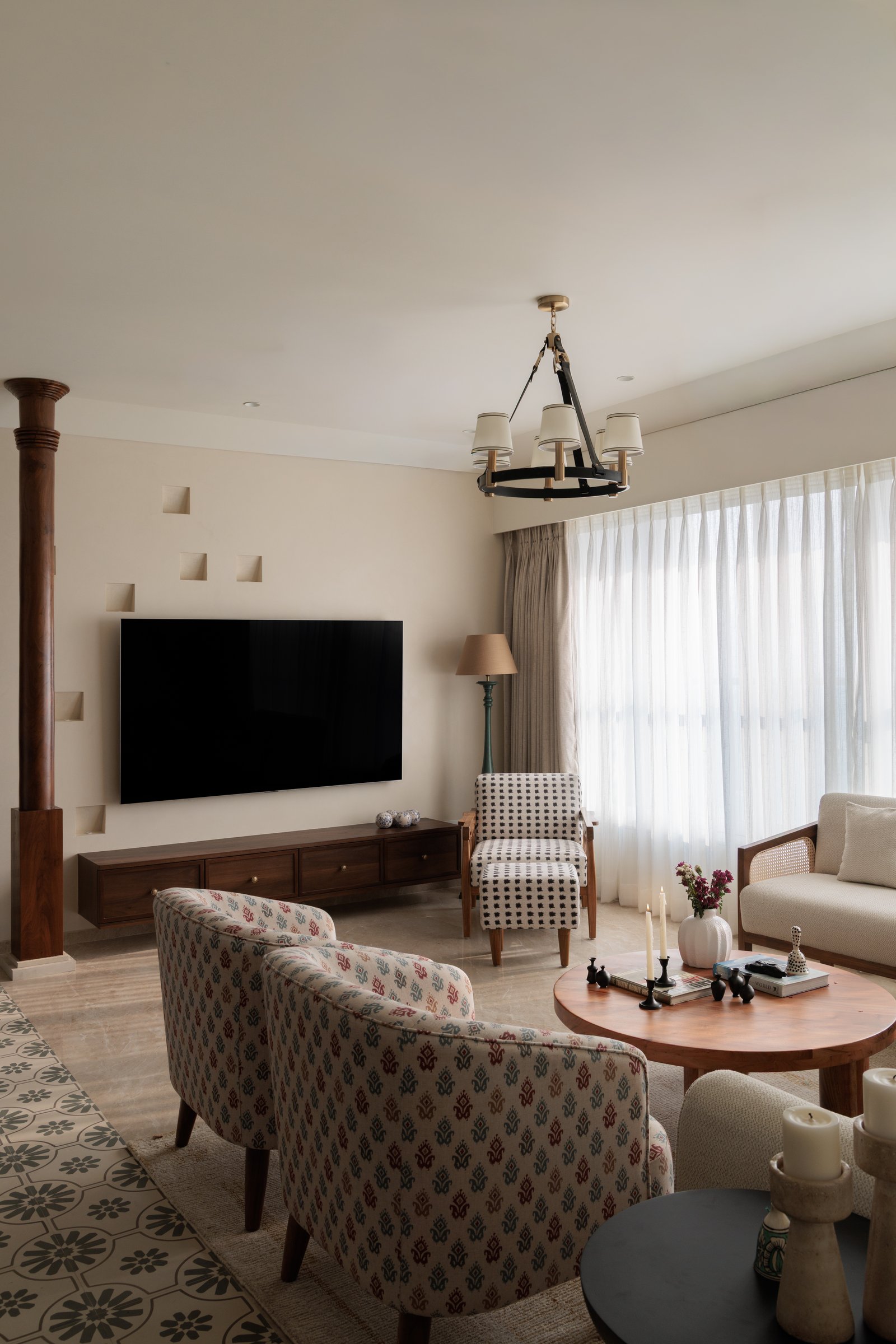 The living room's TV wall, where a turned timber column and recessed pyramidal niches bring craft detailing to an everyday surface