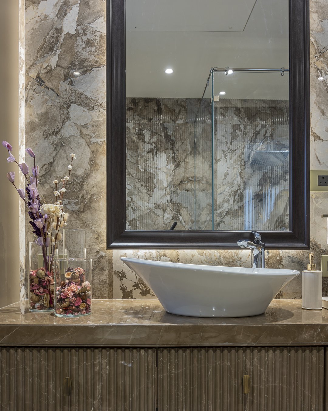 Veined stone and a fluted vanity base in one of the home's bathrooms